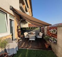 Terrace of a 2-room apartment with wooden decor and garden seating on M. R. Štefánik Street in Most pri Bratislave.