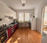A kitchen with light cabinets, a floor with a wood decor in a 2-room apartment.