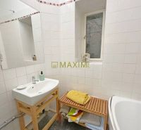 A bathroom in a 3-room apartment with a sink, bathtub, and storage space.
