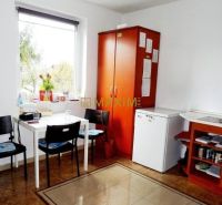 A kitchenette with wooden decor, a table, chairs, and a refrigerator in a cabin.