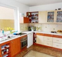 A kitchen in a cabin with wooden decor and white appliances.