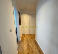 A hallway in a 3-room apartment with a wooden decor floor and white walls.