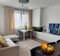 Living room in a 3-room apartment with a comfortable sofa, television, and dining area.