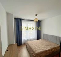 Bedroom in a 2-room apartment with a bed and a wooden decor floor.
