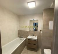 Bathroom in a 2-room apartment with a bathtub, sink, and light tiles.