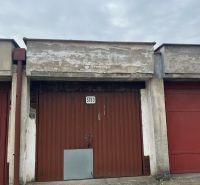 Garages on Dopravná Street in Piešťany with a worn-out gate and gray facade.