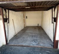 An open garage on Dopravná Street in Piešťany with a concrete floor and a broom.