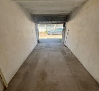 A garage with open doors on Dopravná Street in Piešťany, concrete floor.