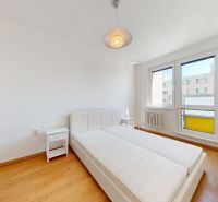 A bright bedroom with a bed and a wooden decor floor in a two-room apartment.