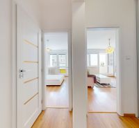 A hallway in a 2-room apartment with doors to the bedroom and living room.