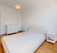 Bedroom in a 2-room apartment with white furniture and a wooden decor floor.