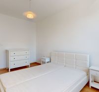 A bedroom in a 2-room apartment with a bed, a dresser, and a floor with a wooden decor.