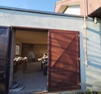 A family house in Veľké Úľany with open wooden doors to the workshop.