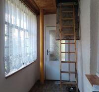 Interior of a family house with a wooden decor floor, stairs, and curtains.