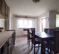 Dining room with a wooden table and chairs in a family house.