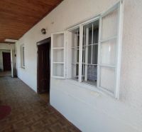The veranda of a family house with a wooden ceiling and white plaster.