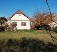 A family house in Veľké Úľany with a garden and greenery under a blue sky.