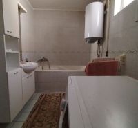 Bathroom in a family house with a bathtub, sink, and washing machine.