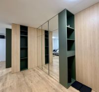 Built-in wardrobes with shelves in a 2-room apartment, floor with wood decor.