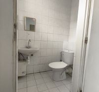 A restroom with white tiles in commercial premises.