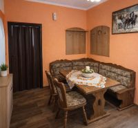 Dining area with a sofa set and table, floor with wooden decor.