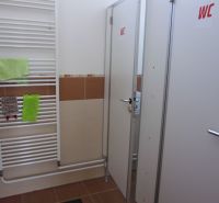 Toilet with radiator and cubicles in commercial premises.