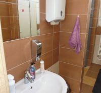 A sink with soap and a hand dryer in commercial premises.