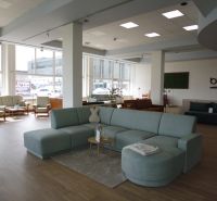 The commercial space offers a view of sofas and armchairs with a wooden decor floor.