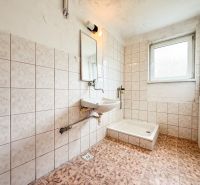 A bathroom with a shower cabin tiled in a 3-room apartment.