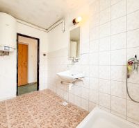 Bathroom with a sink, boiler, and light tiles in a 3-room apartment.