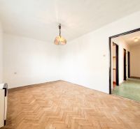A room in a 3-room apartment with a wooden decor floor and a hanging lamp.
