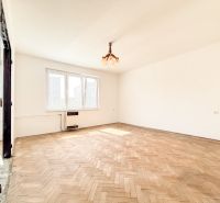 A spacious room with a wooden decor floor and a large window in a 3-room apartment.