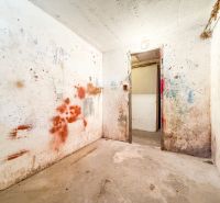 A white room with damaged walls and a long corridor in a 3-room apartment.