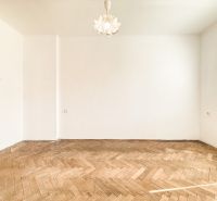 A room with a wooden decor floor and white walls in a 3-room apartment.