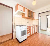 A kitchen in a 3-room apartment with a wood-patterned floor and light-colored furniture.