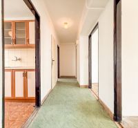 A hallway with linoleum, wooden decor in the kitchen, 3-room apartment.