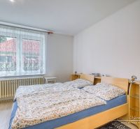 A bedroom in a family house with a large window and a double bed.