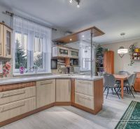 A kitchen in a family house with a wooden decor floor, equipped with kitchen furniture.