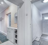 A hallway in a family house with white walls and practical storage space.