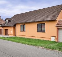 A family house on a street in Špačince with a gable roof and an orange facade.