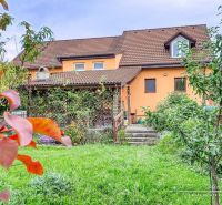 A family house in Špačince on Špačinská Street with a landscaped garden and an orange facade.