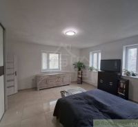 A bright bedroom in a family house with storage space and a window.