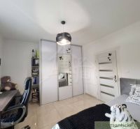 A room in a family house with a desk, a wardrobe, and decorations.