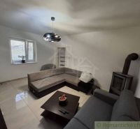 Living room in a family house with a fireplace stove and a corner sofa.
