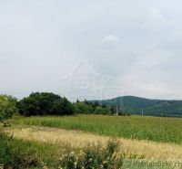 Agricultural and forest land in Smilno with meadows, trees, and hills in the background.