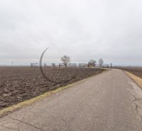 An asphalt road runs through agricultural and forest land in Zohor on Dolná.