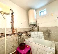 A bathroom in a family house with tiles and a white boiler.