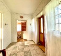A hallway in a family house with a mosaic floor and light-colored walls.