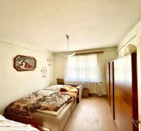 Bedroom interior in a family house with a bed and wooden floor decor.
