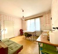 Dining room with vintage wallpaper and simple furniture in a family house.